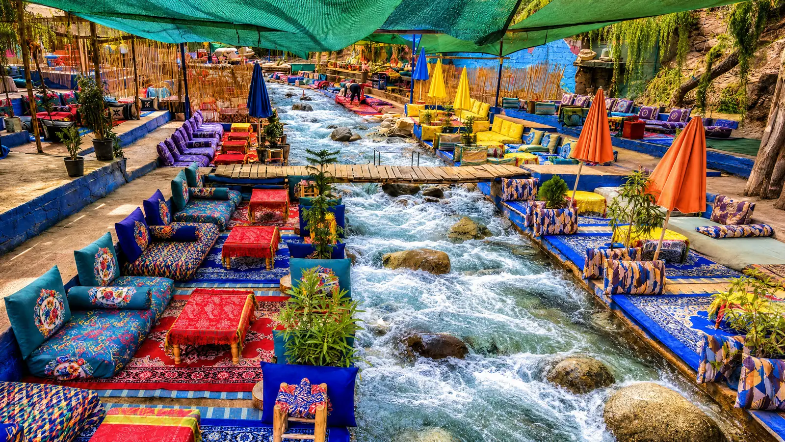 Colourful cushions and low tables set in the stream of the Ourika river