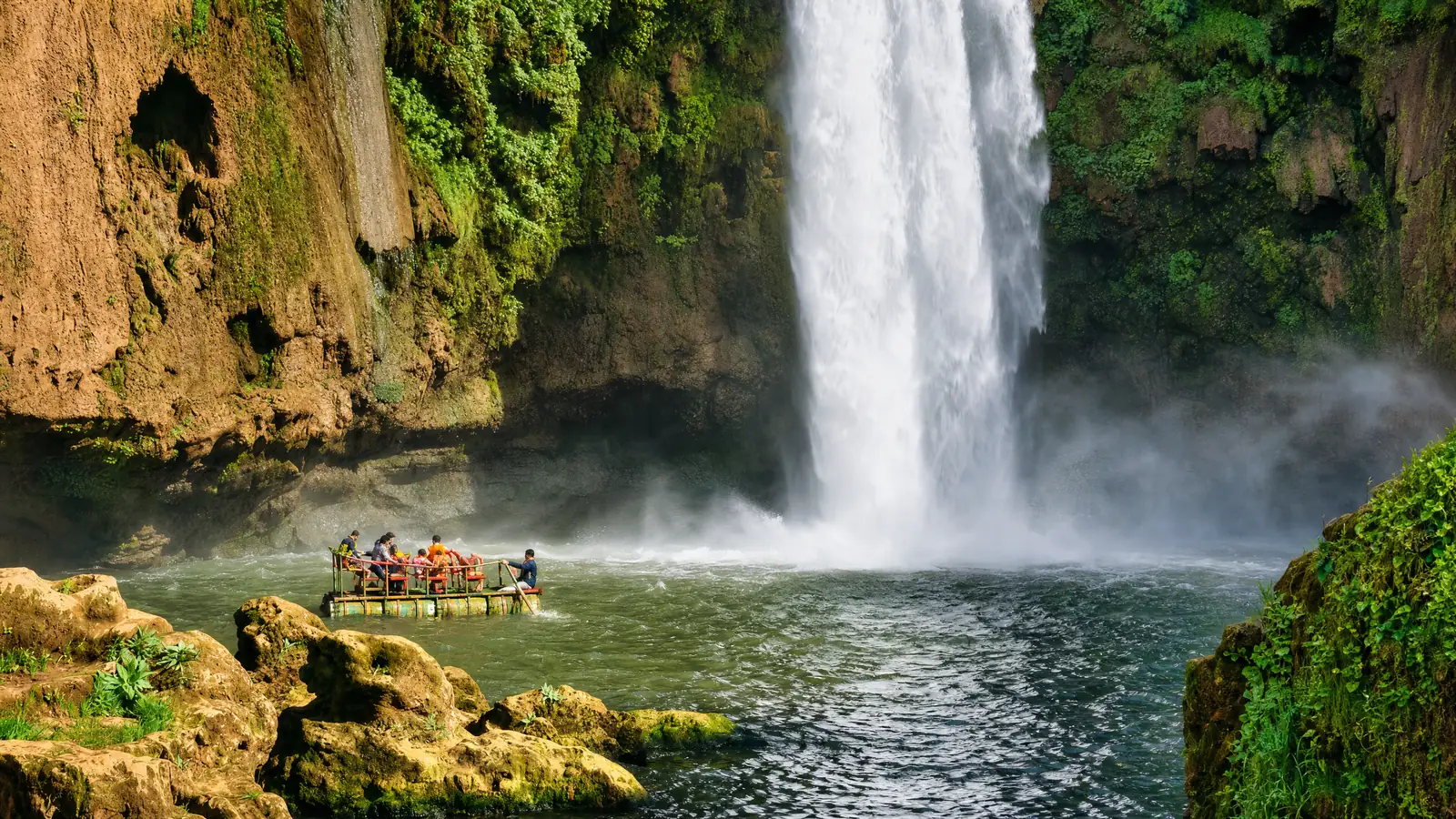 Un radeau de voyageurs sur le bassin au pied des cascades d'Ouzoud