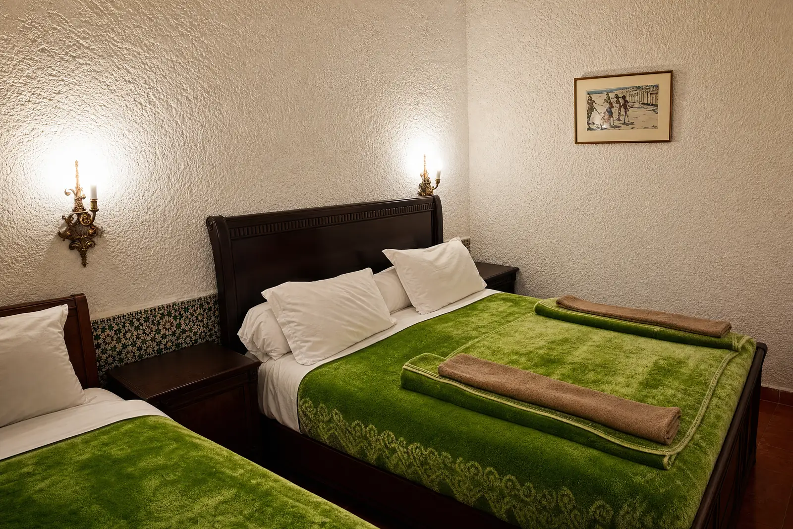 A bedroom with a green bedspread at Hôtel Rose Mgouna