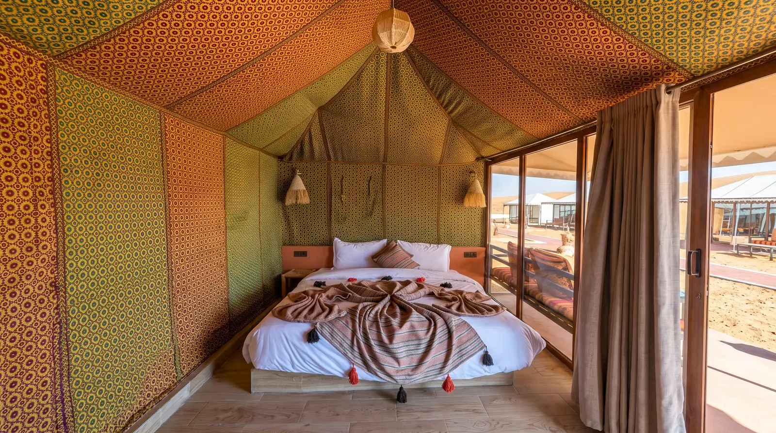 A luxury tent with a double bed at Merzouga Dunes Luxury Camps