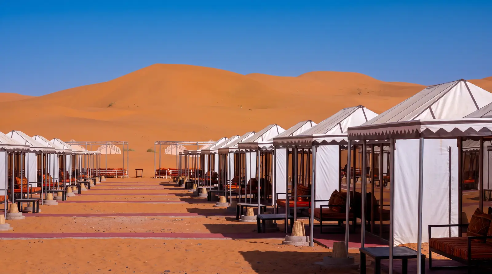 A row of tents facing the dunes at Merzouga Dunes Luxury Camps